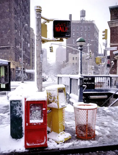 Entrance in the snow of Christopher Street Station at the corner of Grove Street and W.4 Street with traffic light for pedestrians in NY, USA,