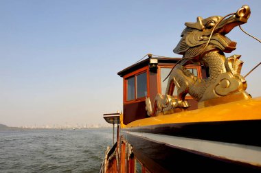 Batı Gölü 'nde tekne gezisi. Arka planda Çin' deki Hangzhou şehri.
