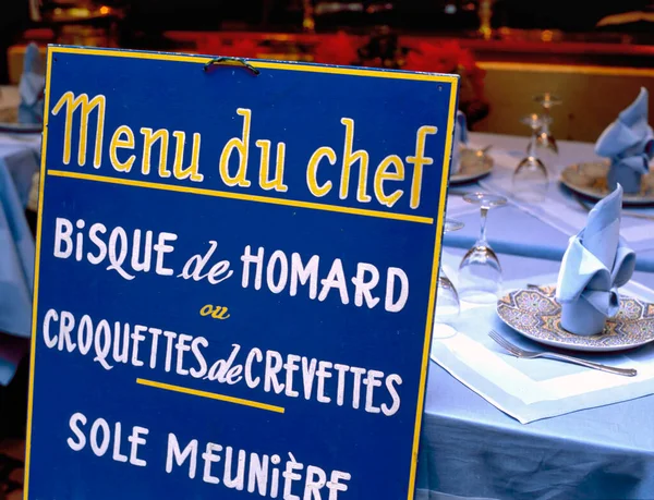 Menu du chef sign at a French restaurant. Translated into english the text is: Menu of the chef with Lobster bisque, Shrimp croquettes and Fillet of sole