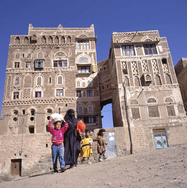 Sana Yemen June 2017 在街上带着三个女儿回家的被审查的母亲 免版税图库图片