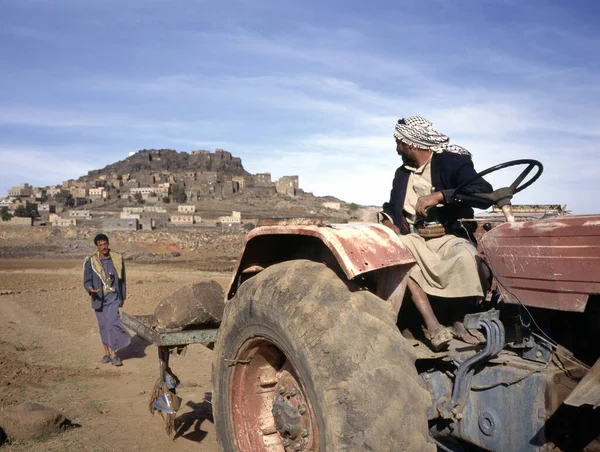 Darb Hashimi Yemen April 2019 两名农民在也门农场用拖拉机干活 背景是他们在也门西北部Saada社区的家乡 图库图片