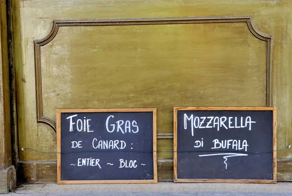 프랑스의 샵에서 보드에서 영어로 프랑크어로 작성됩니다 Foie 그라프 조각과 버팔로 스톡 사진
