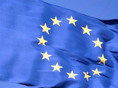 Açık mavi gökyüzüne karşı Avrupa Birliği 'nin renkli ulusal bayrağını sallıyor