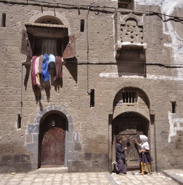 SANAA, YEmen-APRIL 21, 2011: Şehrin merkezindeki geleneksel evlerinin önünde oynayan iki çocuk