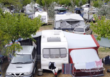 Overview of a crowded camping in Spain with tents, motorhomes and caravan clipart