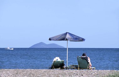 Relaxing on the beach of Samos near the coastline clipart