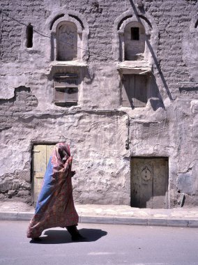 Yemen 'in başkenti Sanaa' da çarşaflı bir kadın sokakta yürüyor. Yemen 'de tipik bir evin önünden geçiyorduk.,