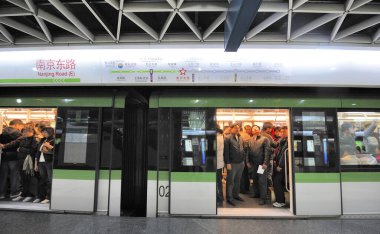 SHANGHAI, ÇİN-NOVEMBER 29,2008: Şehir merkezindeki metro istasyonunda kalabalık bir metro treni. Durak noktaları Çince ve İngilizce yazılmıştır.