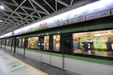 SHANGHAI, ÇİN-NOVEMBER 29,2008: Şehir merkezindeki bir metro istasyonunda metro treni. Durak noktaları Çince ve İngilizce yazılmıştır.