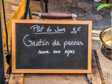 Fransa 'da bir restoranda günün tabağı tabelası. Tabak, mantar soslu kremalı makarna.