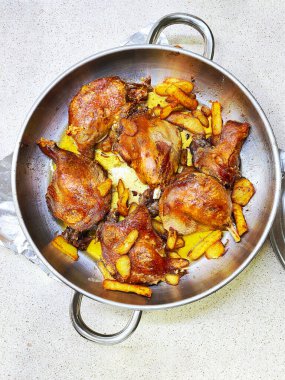 Confit de Canard yanında patates kızartması, ördek bacağından yapılan geleneksel bir Fransız yemeği, yavaşça kendi yağında pişiriliyor..