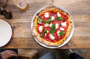 Geleneksel Pizzeria 'da ahşap bir masada taze pişmiş Napoli Margherita Pizza..
