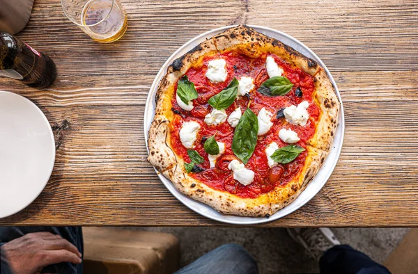 Geleneksel Pizzeria 'da ahşap bir masada taze pişmiş Napoli Margherita Pizza..