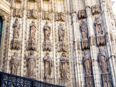 Sevilla Katedrali 'nin ana girişi olan Puerta de la Asuncion kapısının yanındaki oyuklarda bulunan havarilerin ve azizlerin heykelleri serisi. Sevilla, Endülüs, İspanya.