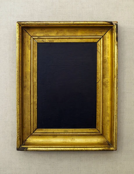 Antique golden art fair gallery frame with blank oil paint texture copy space, on the wall at museum exhibition.