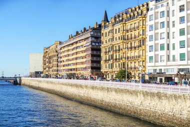 San Sebastian, İspanya - 13 Mart 2024. Ramon Mara Lili Gezinti Alanı Urumea Nehri boyunca, arkasında Kursaal Sarayı ile birlikte. Donostia, Bask Bölgesi, Guipuzcoa. İspanya.