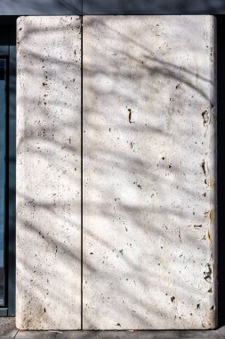 Ağaçların gölgeli beyaz mermer bir duvar..