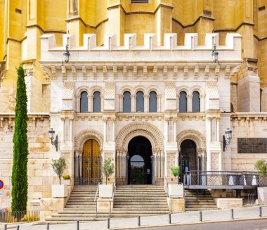 Madrid 'deki Almudena Katedrali mahzeninin süslü girişi, kemerli kapı araları, sütunlar ve ayrıntılı taş işçiliği yer alıyor..