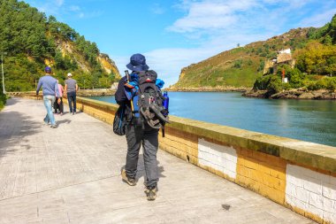 San Pedro, İspanya - 5 Ekim 2024. Pasajes Körfezi 'nde yürüyen bir hacı, Camino de Santiago' nun kuzey rotasındaki Pasajes de San Pedro kasabasından geçiyor..