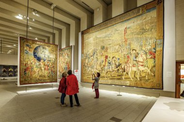 Madrid, İspanya - 4 Kasım 2024. Wilhelm Pannemaker 'ın 1548-1554 yılları arasında Kraliyet Koleksiyonları Galerisi' nde yaptığı La Revista de las tropas en Barcelona duvar halısına iki kadın hayran..