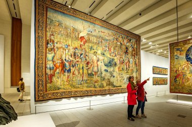 Madrid, İspanya - 4 Kasım 2024. Kraliyet Koleksiyonlar Galerisi 'ndeki duvar halısında iki kadın Scipio ve Hannibal duvar halısı konferansının önünde duruyor. Yazan Giulio Romano ve Balthazar van Vlierden..