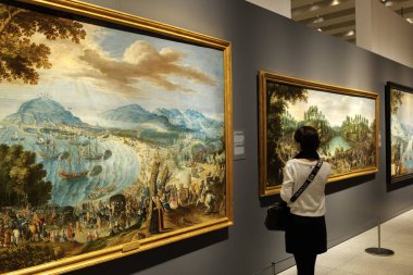 Madrid, Spain - November 4, 2024. A visitor observes paintings in the Gallery of the Royal Collections, in a room dedicated to the Habsburg dynasty. clipart