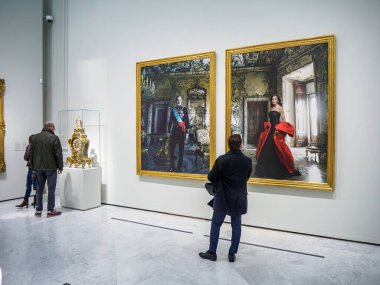 Madrid, İspanya - 3 Aralık 2024. İspanya monarşisini tasvir eden Annie Leibovitz 'in İspanyol krallarının kraliyet portrelerine hayran kalarak Banco de Espana' daki The Tyranny of Chronos sergisine gelen ziyaretçiler.