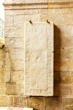 Saint-Jean-de-Luz, Fransa - 29 Ocak 2025: Saint-Jean-de-Luz, Yeni Aquitaine, Fransa 'daki Saint-Jean-Baptiste Kilisesi' nin girişine açılan geçidin tuğla duvarında 1621 yılından kalma tarihi bir mezar taşı.