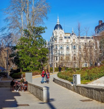 Madrid, İspanya - 9 Şubat 2025. Madrid, İspanya 'da ikonik modernist bir bina olan Casa Gallardo' nun manzarasında insanlar Plaza de Espana 'da yürüyor ve güneşli bir günün tadını çıkarıyorlar..