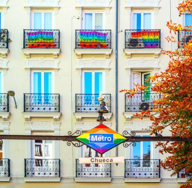 Madrid, İspanya - 12 Mayıs 2025. Chueca Metro tabelası gökkuşağı renkleri ve balkonlarla süslenmiş Gay Onur Günü için bayraklarla.