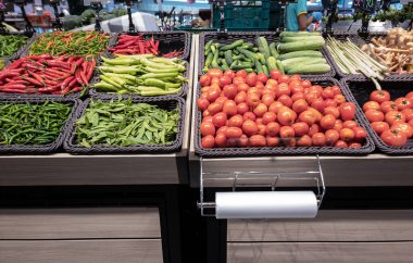 Markette sebzeler satılıyor. Markette çeşitli sebzeler ve plastik bir torba.. 