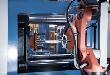 Otomatik üretim süreci. Robot kolu enjeksiyon kalıbındaki ürünleri kaldırır.