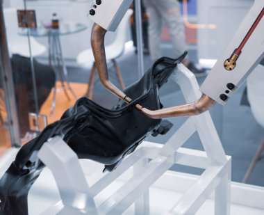 Robot kolu, kaynak yapan araba parçalarını gösteriyor. Otomotiv fabrikasında akıllı endüstriyel üretim.