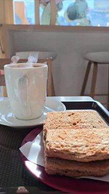 Bir fincan dumanlı kahve ve bir tabak tereyağlı ekmek..