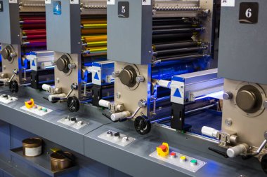 Esnek, çok renkli endüstriyel baskı makinelerinin detaylı görüntüsü. Modern ambalaj ve baskı teknolojisi.