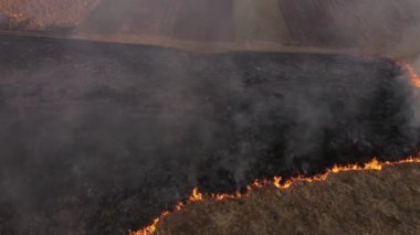 Yay manzaralı kuru çimenlerin yanma alanı. Çayırlarda yangın ve duman, doğa kirliliği ve tehlike, çalılar ve yaygın atıklar yakılıyor