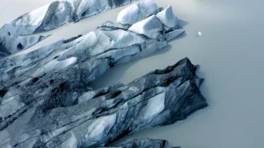 Aerial view of Solheimajokull glacier, Iceland. Crevasse and black volcanic ash captured in the ice. Global warming and climate change concept