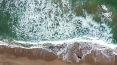 Kumlu sahilleri yıkayan deniz dalgalarıyla tropikal bir cennetin üzerinde uçuyorlar. Hava aracı görünümü