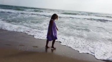 Kumsalda yürüyen seksi sarışın kadın.