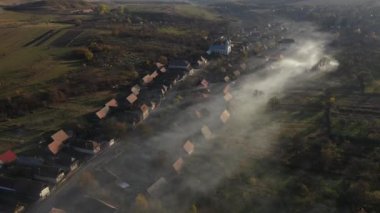 Bir köyün üstündeki sabah sisinin havadan görünüşü. Çatılar bulutlardan drone 'larla yükseliyor.