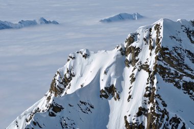 Kar, yüksek dağları, sisi ve bulutları kapladı. Alpler, Avusturya