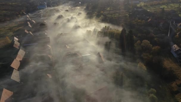 从空中俯瞰村庄上方的晨雾 无人驾驶飞机从云中升起的房屋屋顶 — 图库视频影像