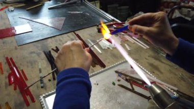  Sanatçı ellerine yaklaş lamba çalışma tekniğiyle cam kolye yap. Gaz ocağı kullanarak cam ve alevi şekillendirmek.