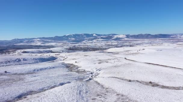 冬の雪に覆われた丘と山の空中眺望 — ストック動画