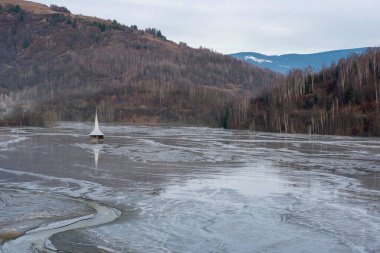 Kilise, bakır ve altın madenlerinin zehirli atık sularıyla dolup taştı. Dekantasyon gölü, Geamana, Rosia Montana, Romanya