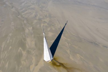 Çamur ve maden kalıntılarının altında gömülü haçlı bir kilise kulesinin havadan görüntüsü. Romanya 'nın Transilvanya kentinde kıyamet sahnesi