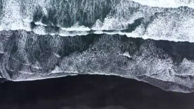  Atlantik okyanus dalgalarının üzerinde, İzlanda 'nın kumlu kıyı şeridini yıkayan havadan aşağıya yavaş çekim