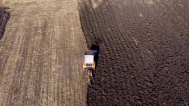 Bahar tarlası işi, ekicili traktör havadaki yavaş çekim tohumlarını eker.