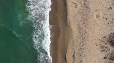 Gözlerden uzak kumlu bir sahil ve insansız hava aracı tarafından deniz dalgaları.