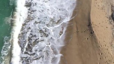 Kumlu sahilleri yıkayan deniz dalgalarıyla tropikal bir cennetin üzerinde uçuyorlar. Hava aracı görünümü